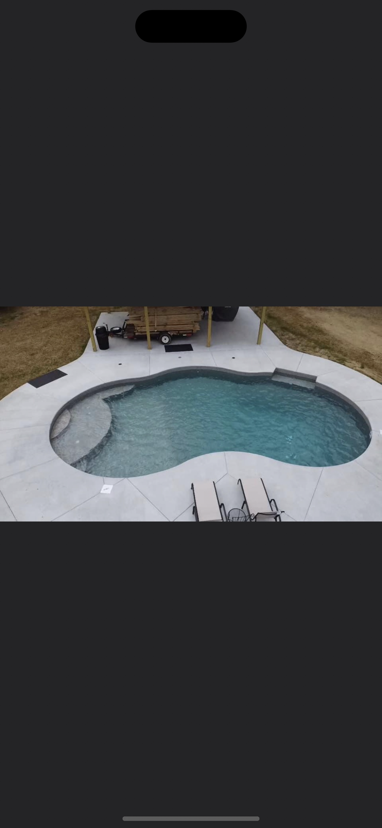 Custom freeform vinyl liner pool with tanning ledge and white concrete deck