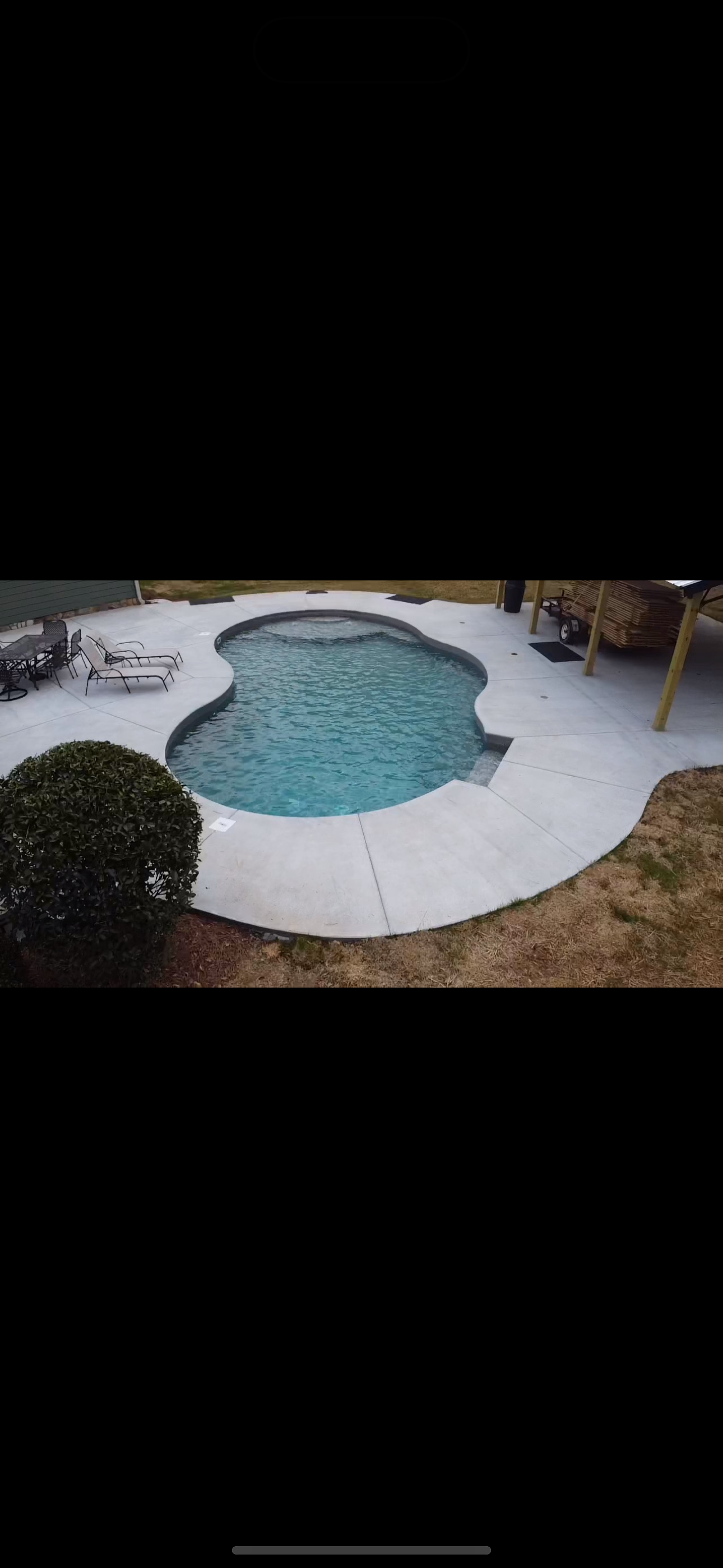 Aerial view of freeform vinyl liner pool with lounge chairs and landscaping